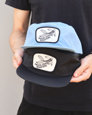 Two stacked blue and black nylon snapback hats