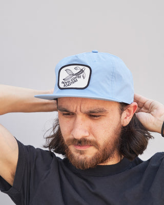 man wearing blue nylon novel coffee roasters hat