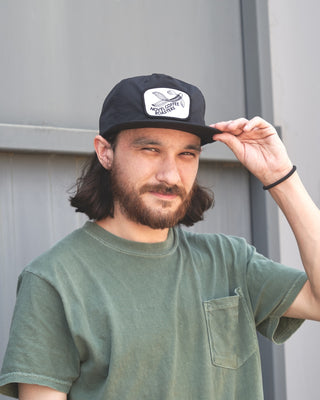 Man wearing black nylon novel coffee roasters hat