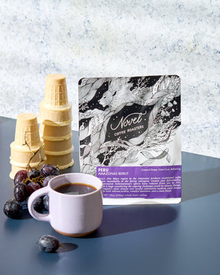 Novel Coffee Roasters Peru coffee package with a cup of coffee, grapes, and cake cones